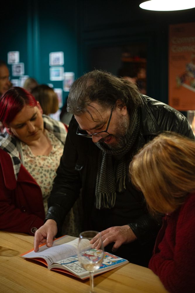 Three people look through the comic book anthology