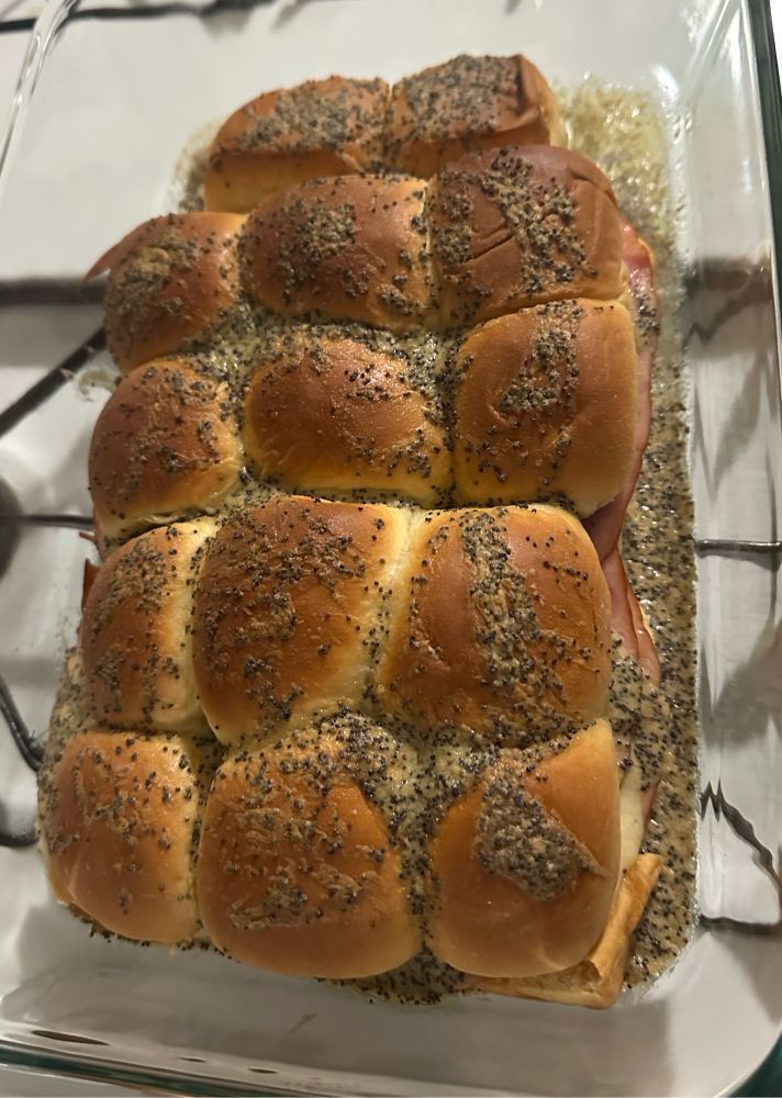 a pan of baked Hawaiian rolls with a dijon poppyseed glaze