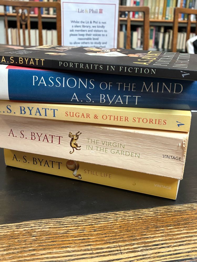 A pile of books by A. S. Byatt, visible from the spine, on a library desk.