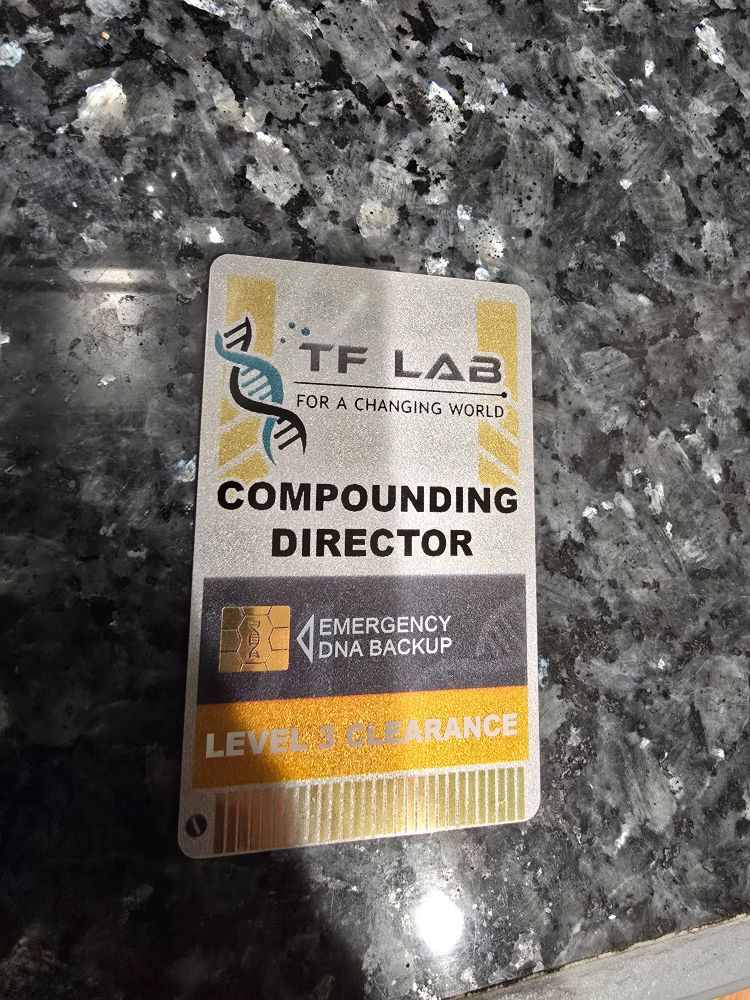 A badge access card that states: TF Lab for a changing world. Compounding director. Emergency DNA backup. Level 3 clearance. The badge has metal chips like a card reader for access
