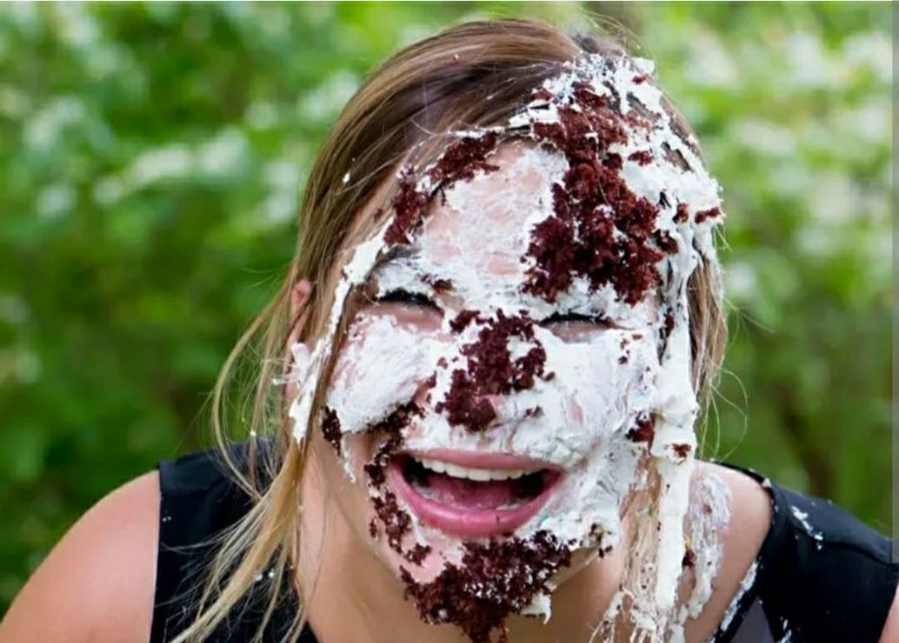 Woman smiling through her cake smash covered face.