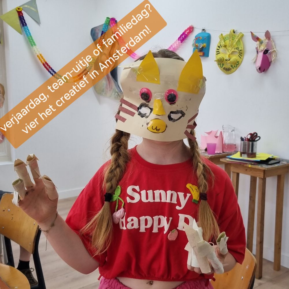 meisje met masker in de vorm van een poes met slingers op de achtergrond en de tekst "verjaardag, team uitje of familiedag? vier het creatief in amsterdam!"