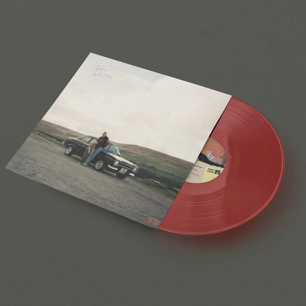 album cover is a child and adult by a car with moor land behind them. red vinyl.