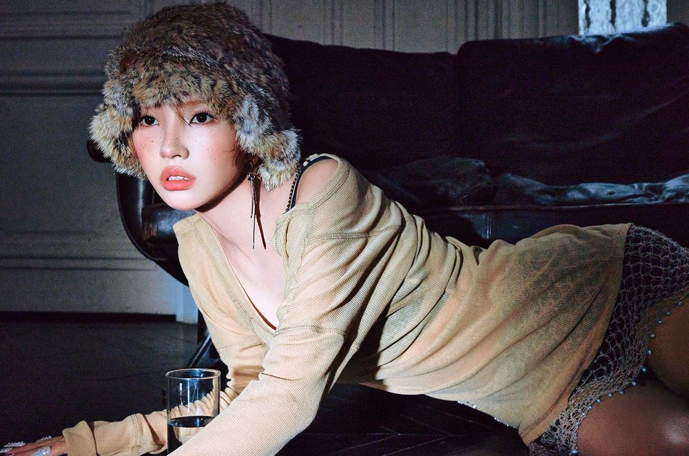 Soyeon (i-dle) lying on the floor, looking toward a light source that illuminates her face