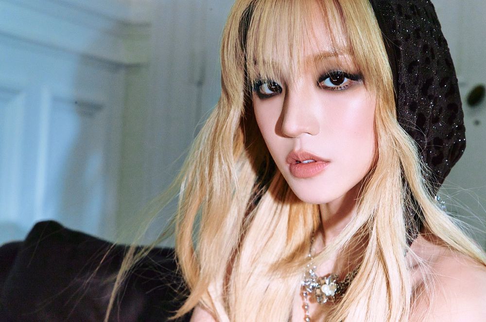 Close up photo of Yuqi (i-dle), she is blonde and is gazing directly into the camera