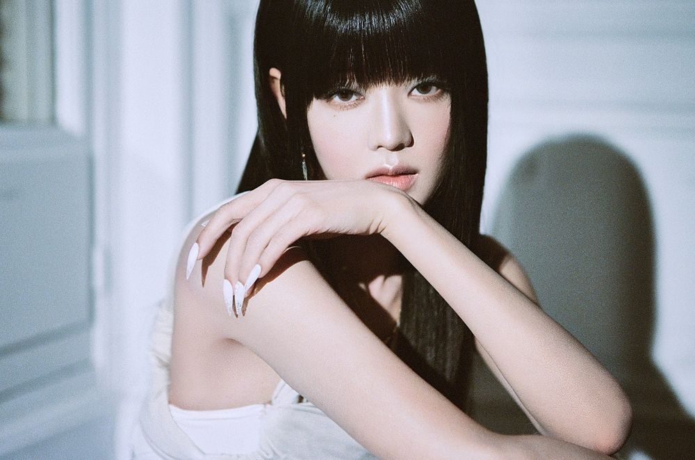 Minnie (i-dle) resting her arm across her face, staring into the camera