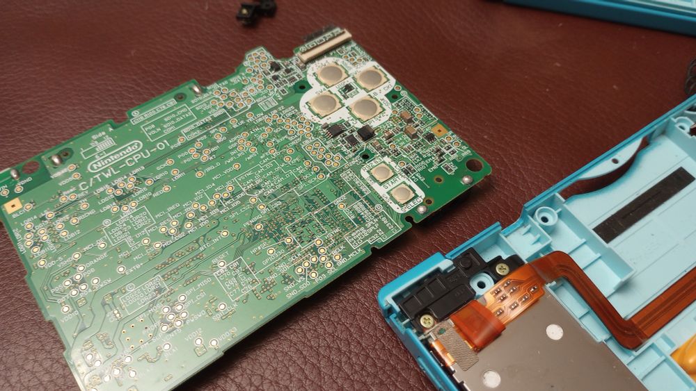 Nintendo DSi with bad shoulder buttons, broken top screen, and brown goo all over the shell (goo already cleaned up)