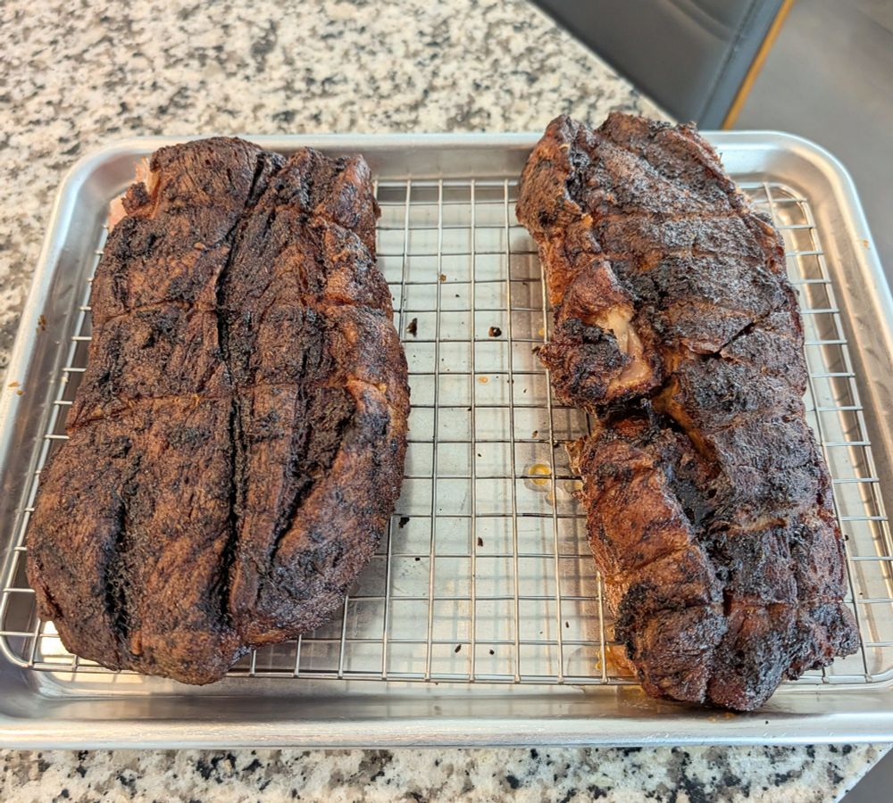 A couple of hunks of long-roasted marinated pork should resting in a pan on a metal grate, and it looks great 