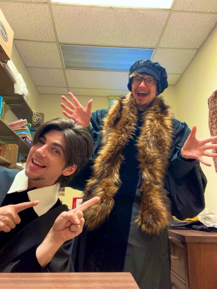 Everett dressed as Thomas Hobbes and Khristian dressed as John Calvin making silly faces in their office.
