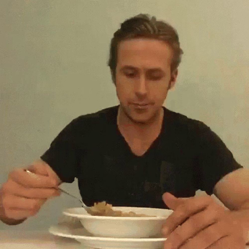 a man in a black shirt is eating a bowl of food