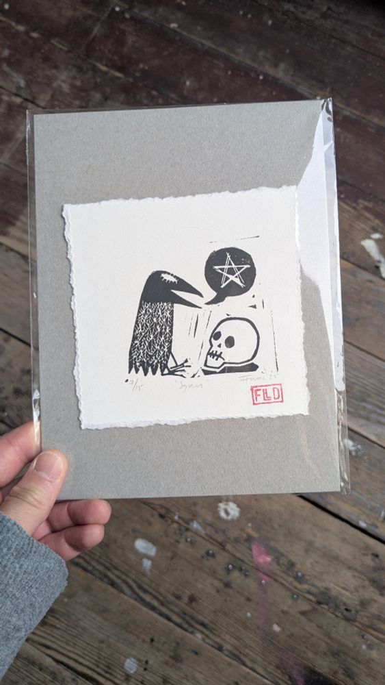 A photo of a lino print by artist Frank Duffy, showing a crow talking about magic to a skull 
