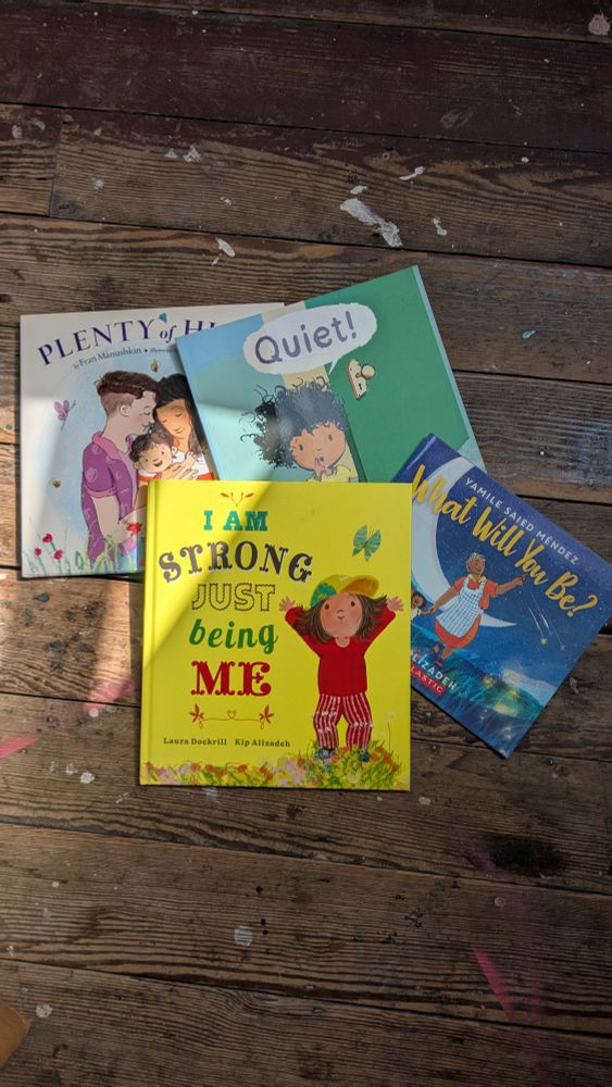 A photo of four books that Kip has made - Plenty of Hugs written by Fran Manushkin, illustrated by Kip Alizadeh, Quiet by Kip Alizadeh, What Will You Be written by Yamile Saied Mendez illustrated by Kip Alizadeh and Strong written by Laura Dockrill and illustrated by Kip Alizadeh 