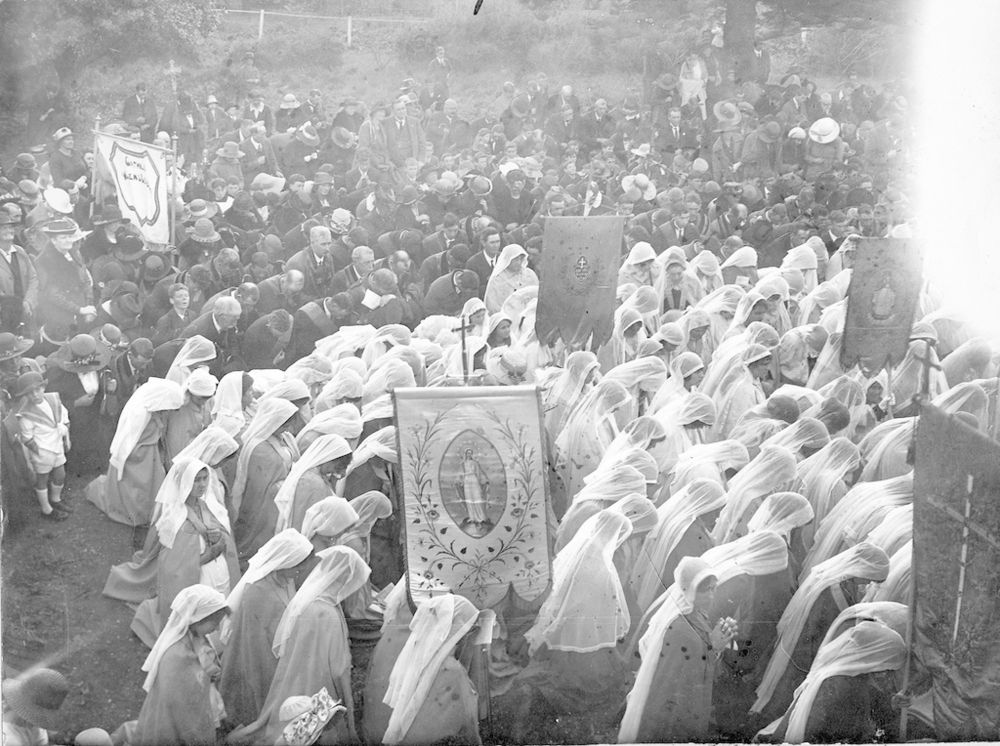 “Roman Catholic religious ceremony, possibly a first Communion event held at Glen Osmond, South Australia; girls wearing white veiling kneel to pray with a large crowd of onlookers.” Photo via the State Library of South Australia, public domain.