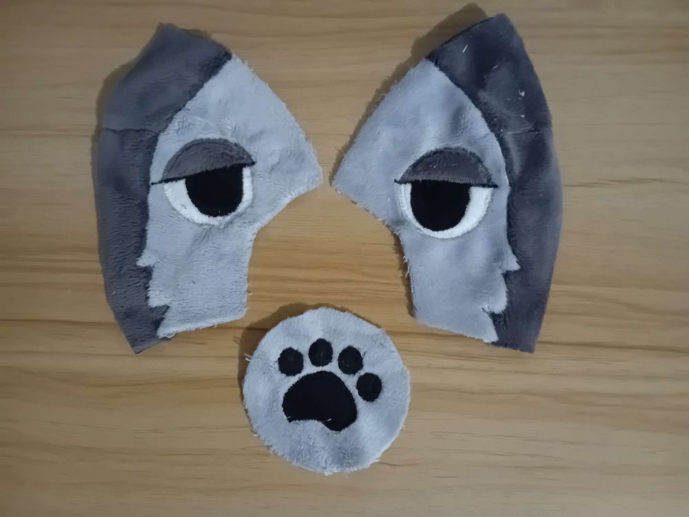 grey minky fabric with embroidered eyes on it, and a paw on another part