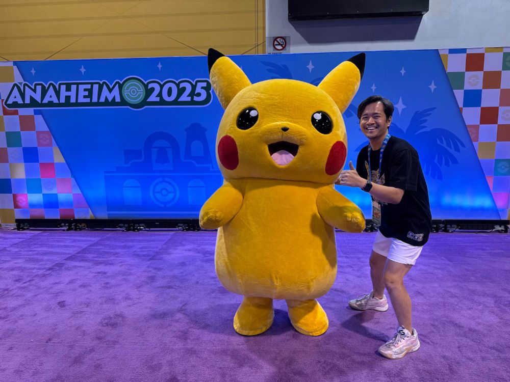 A man posing with a costumed Pikachu for Pokemon World Championships 2025 in Anaheim 