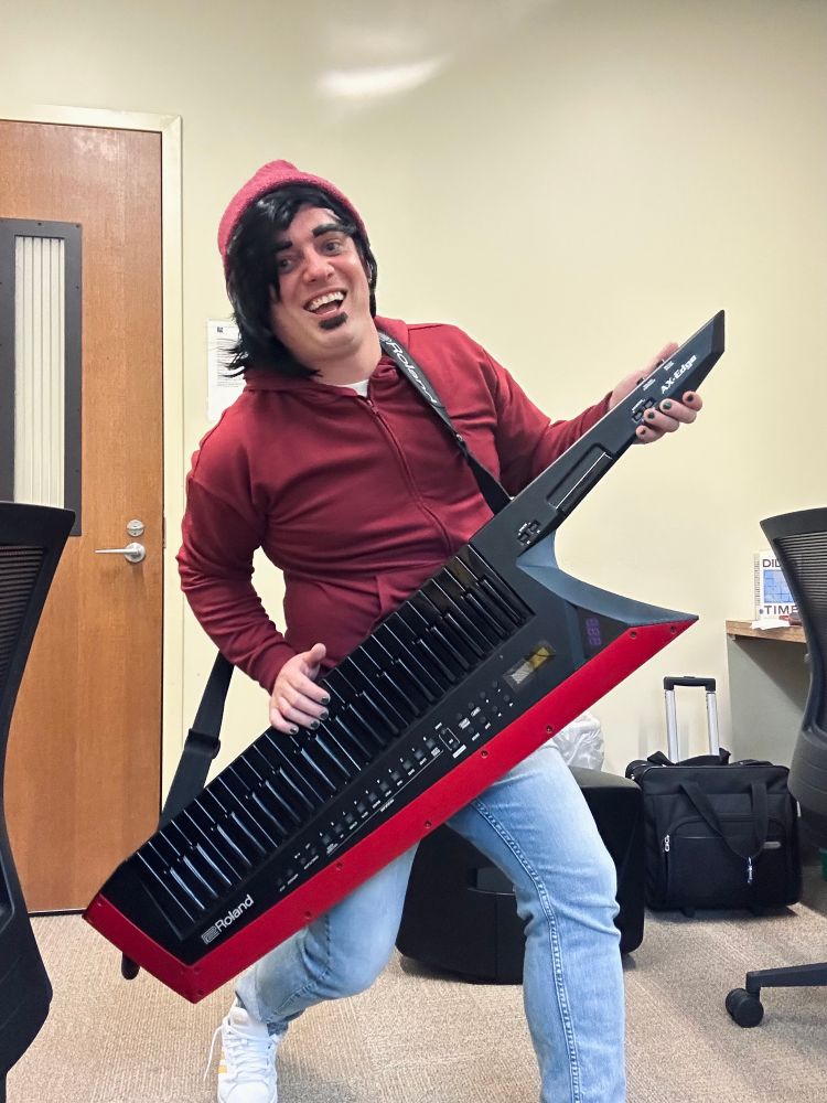 Person dressed up as Chip Skylark holding a keytar. 