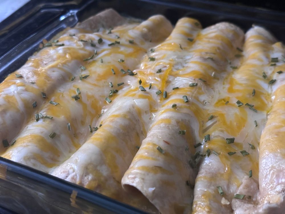 8x8 baking dish with freshly baked low-carb roasted pork salsa verde enchiladas.