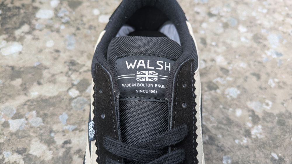 Tongue of Norman Walsh trainer with logo saying "made in Bolton England since 1961"