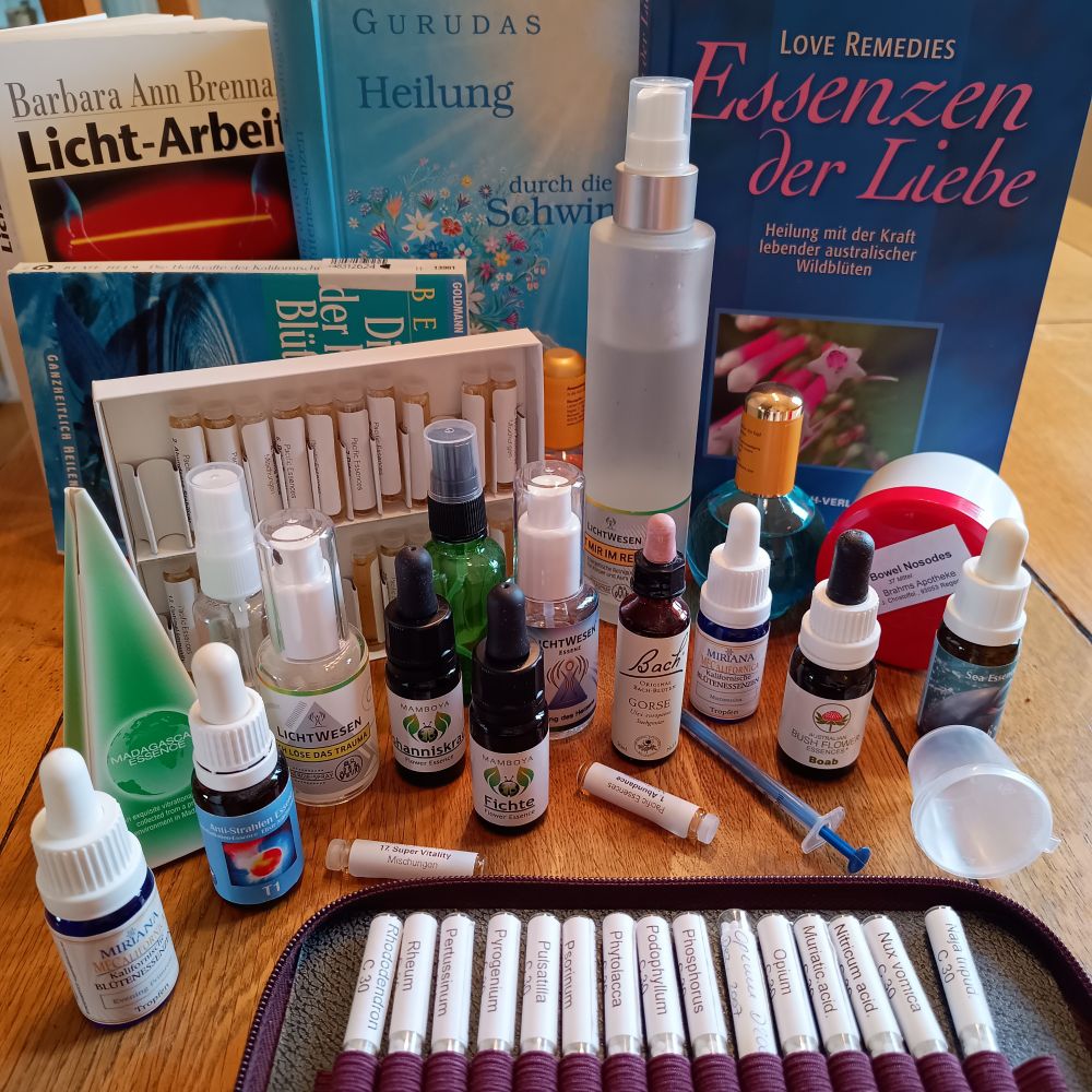 Im Hintergrund ein paar Bücher über Essenzen und Energiearbeit. In der Mitte eine kleine Auswahl meiner Essenzen. (Von ein paar hundert) Im Vordergrund meine homöopathische Hausapotheke.