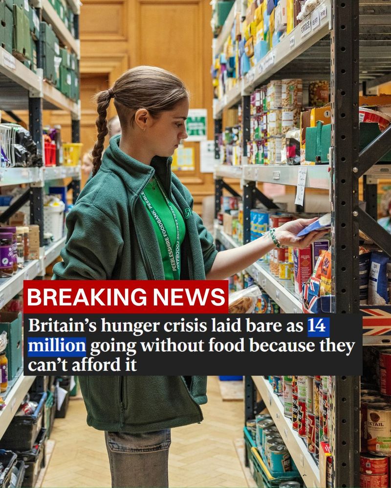 A young woman who works for a food bank is putting items on a warehouse shelf. She is putting a packet of microwaveable rice onto a shelf. A headline from the Independent is on top: 'Breaking news: Britain's hunger crisis laid bare as 14 million going without food because they can't afford it.'