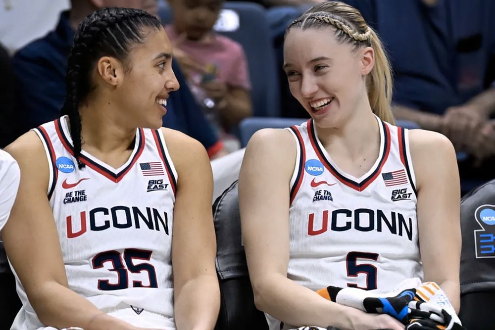 Paige and Azzi laughing together on UCONN bench