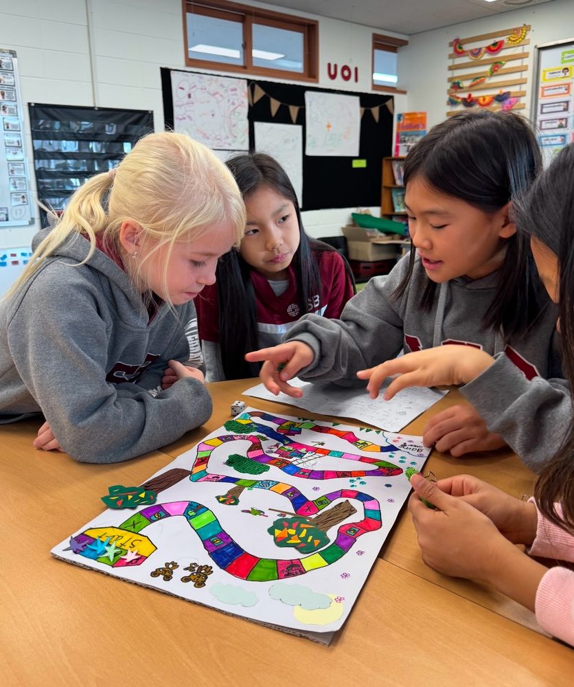 Elementary students playing a board game together.