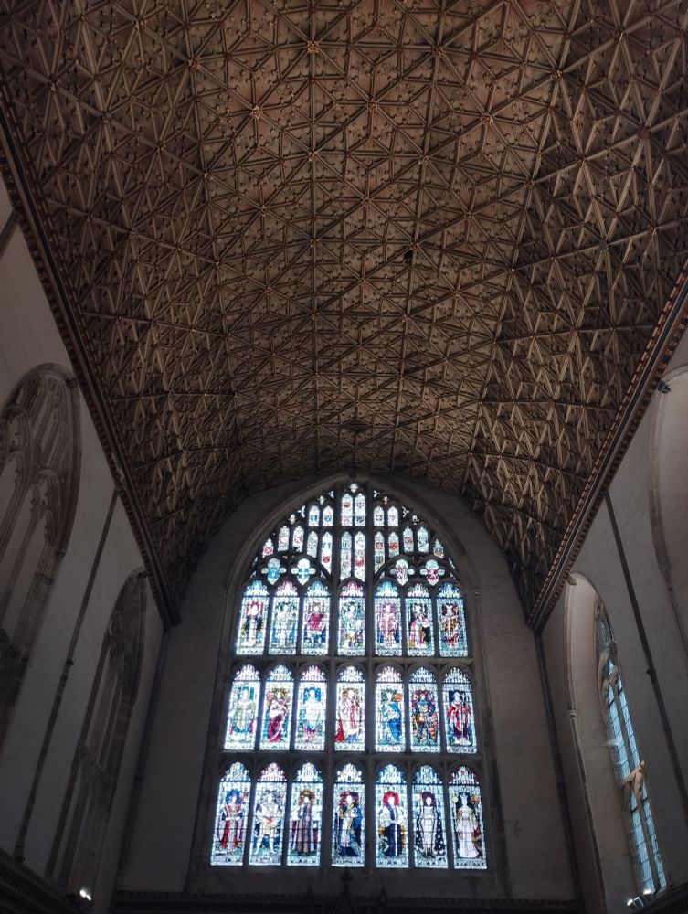 Stained-glass window under an elaborate ceiling 