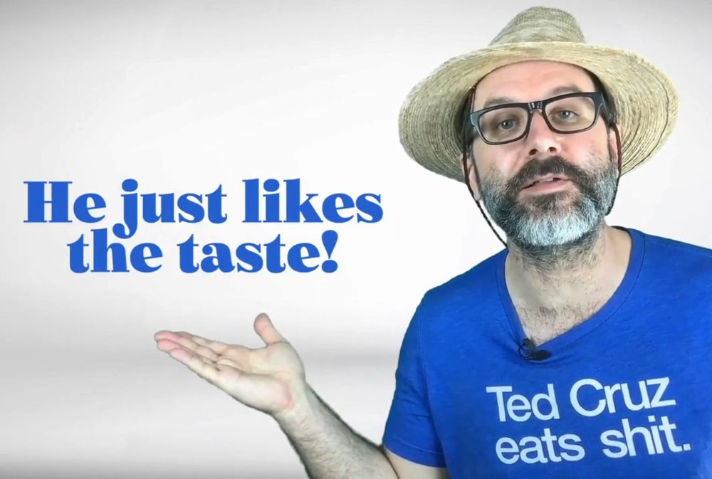 A handsome young man in a shirt that says “Ted Cruz Eats Shit” gestures to a caption that reads “He just likes the taste!”
