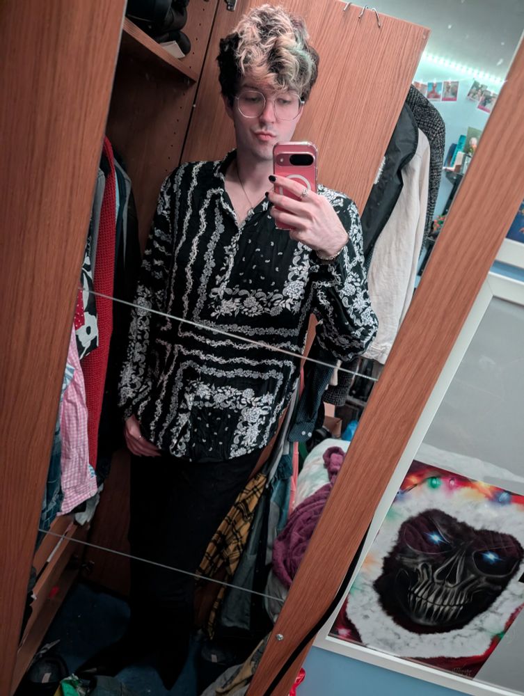 Photo of me dressed in a shirt and black jeans posing in a mirror 