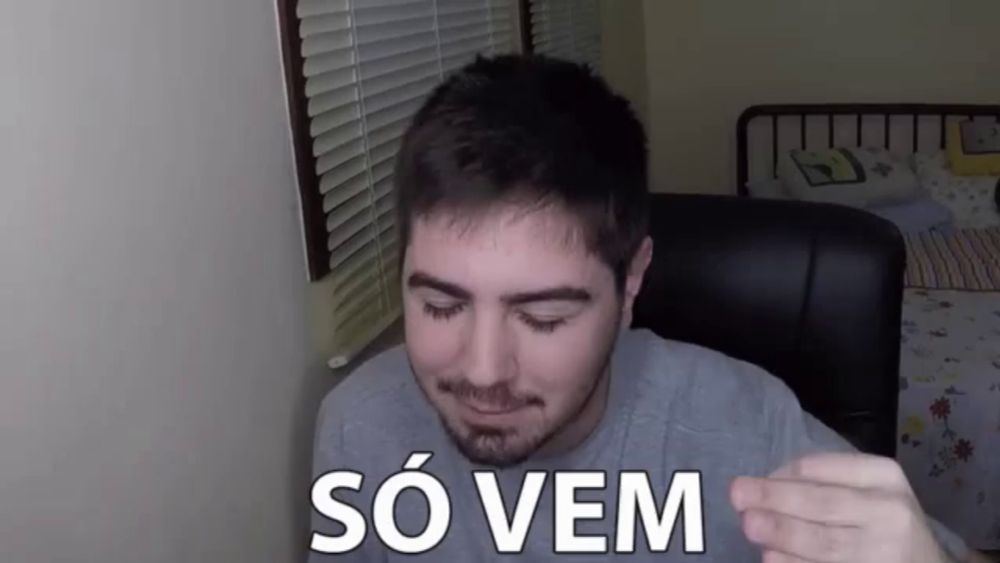 a man is sitting in a chair with his eyes closed and the words so vem written on his shirt .