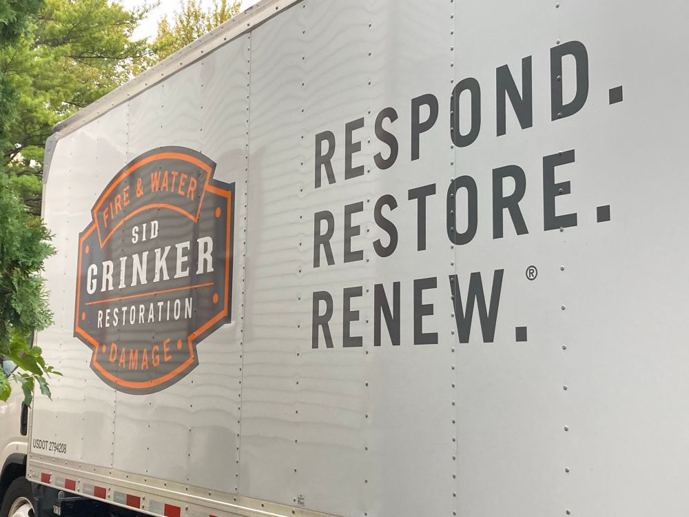 Side of a big truck that says, “SID GRINKER RESTORATION. respond. Restore. Renew.”