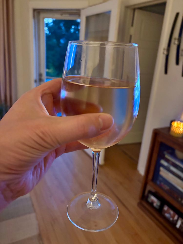 My left hand holding a very full glass of rosé. 