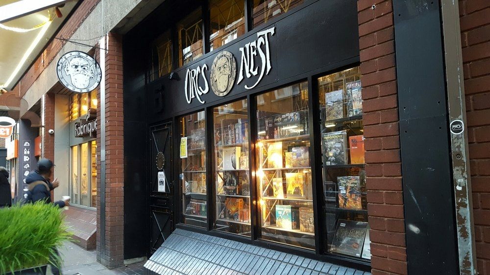 The Orc's Nest shop front in Covent Garden area of London, UK. A small set of windows displays a range of board games boxes and a large sign saying Orcs Nest with a badge of a grumpy orc face