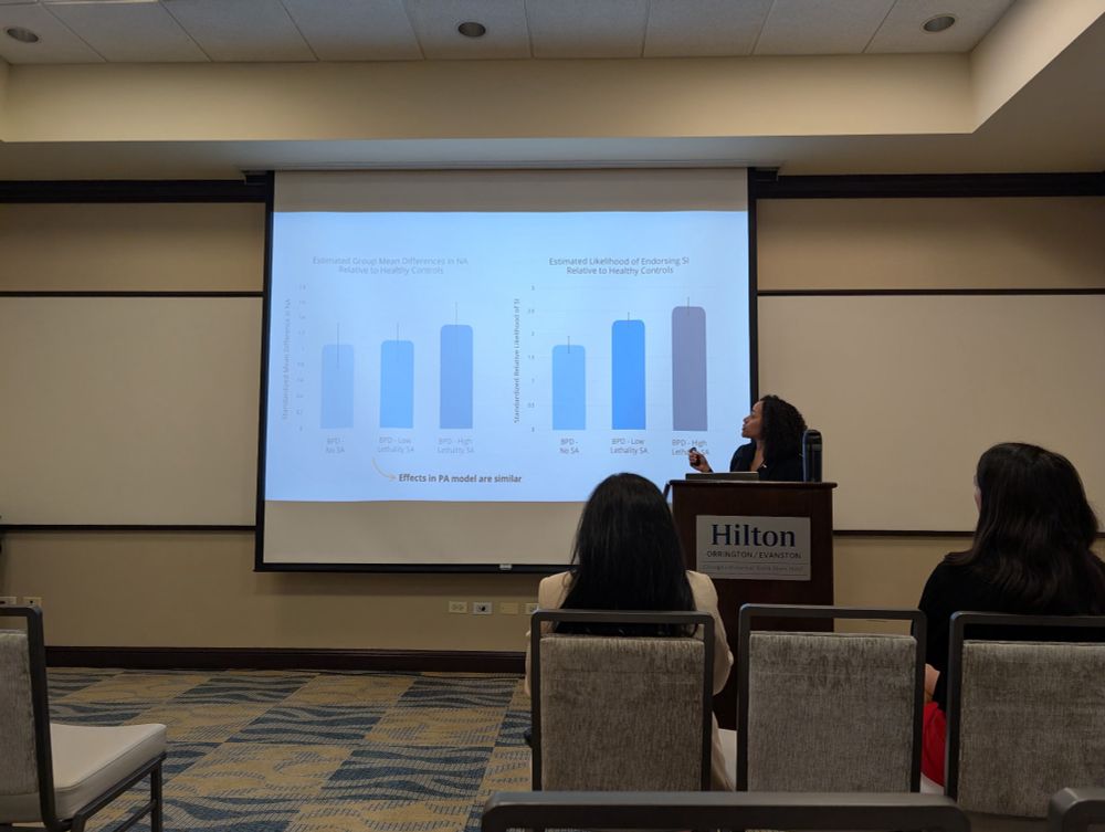 Michaelle standing at a podium with a clicker presenting master’s thesis talk at ARP conference in Evanston IL
