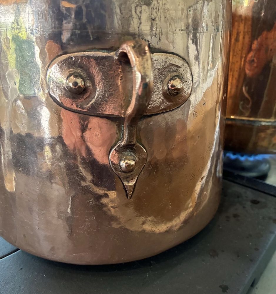 Copper pot with a handle that looks like a face.