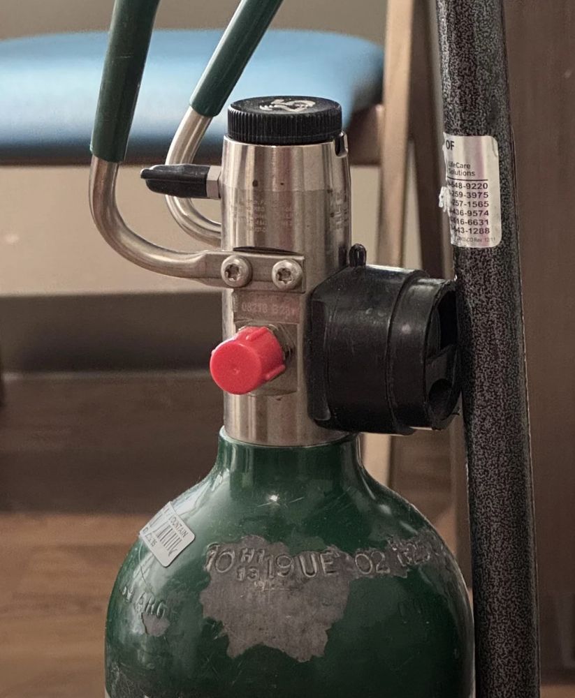 Oxygen tank that seems to have a face with a red nose.