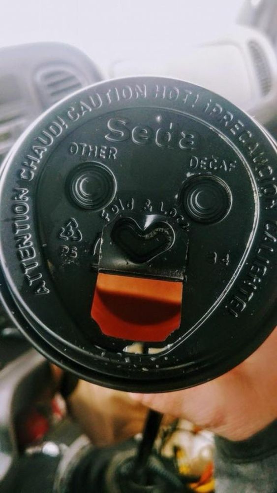 A cardboard cup lid that looks like a face.
