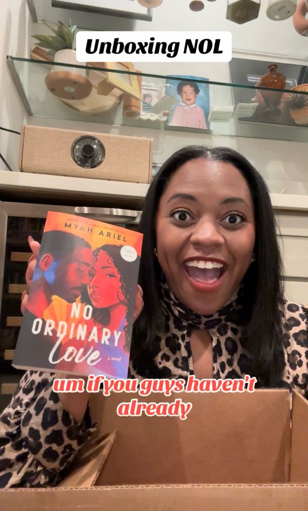 Author Myah Ariel holding up and arc copy of her novel NO ORDINARY LOVE 
