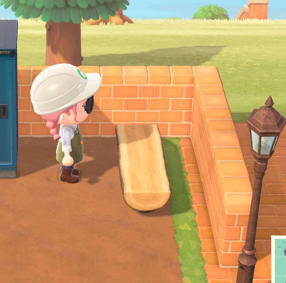 Animal Crossing player character standing in front of a log bench that isn't able to be placed flushed to the wall due to game limitations. 