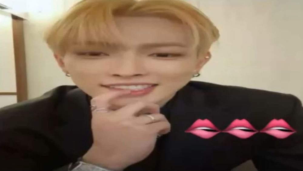 hongjoong touching his bottom lip with lip biting emojis in the bottom right