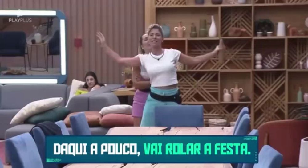 a woman is dancing in a living room with a sign that says daqui a pouco