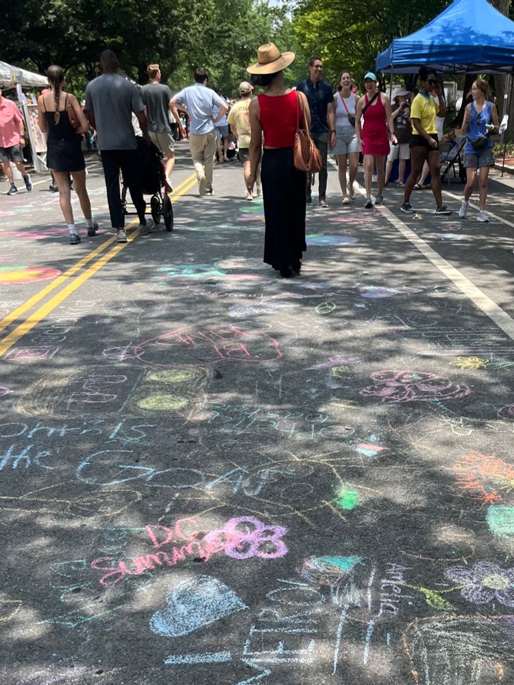 Open Streets DC celebration: the street is filled with chalk drawings and people strolling 