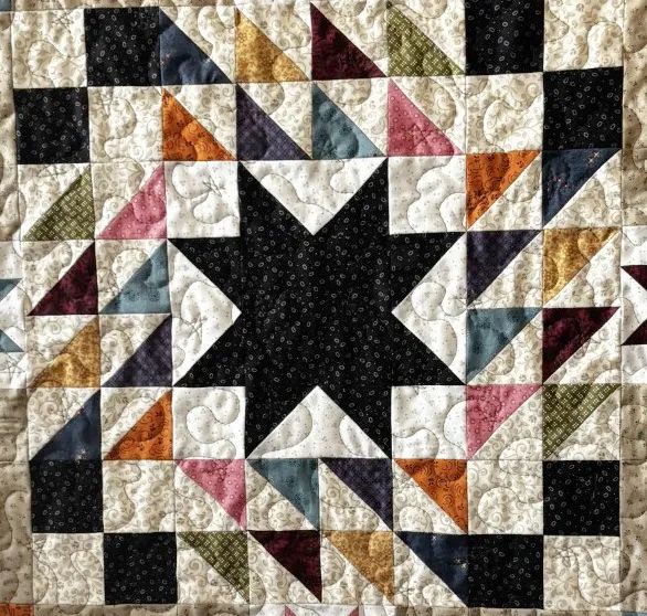 Quilt block made up of a star and triangles.