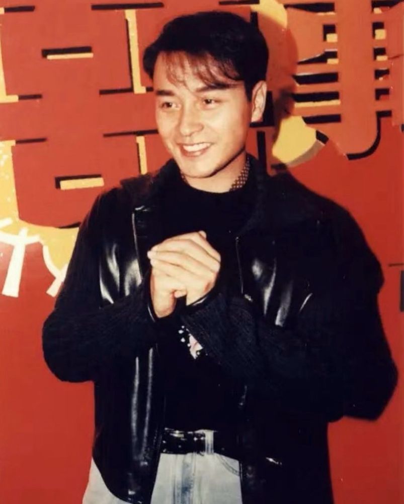 Picture of Leslie Cheung Kwok-wing (張國榮) smiling with both of his hands together.