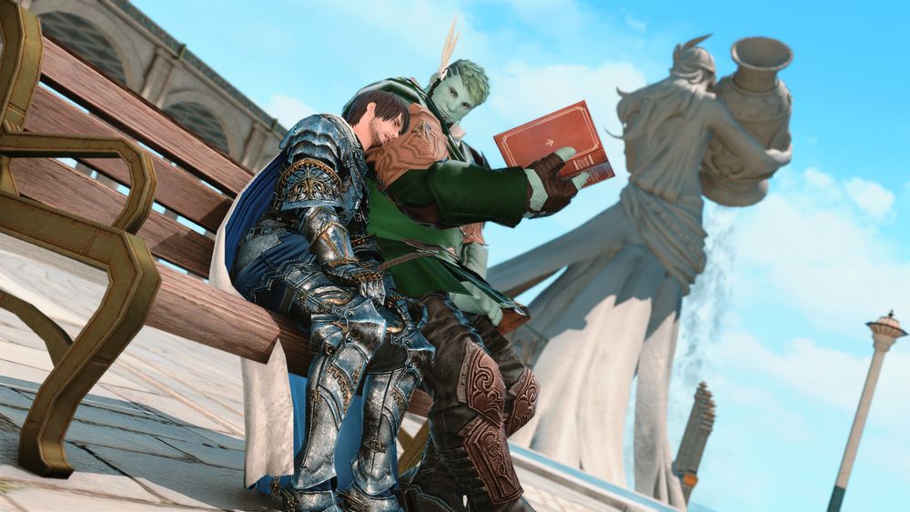 Screenshot of a bench in Sharlayan in view of a large statue of Thaliak that holds an urn unleashing a waterfall of water. Bera, a sea wolf roe dressed in green, reads a book and looks down to his sleeping companion, Meteor, dressed in a full set of armor.