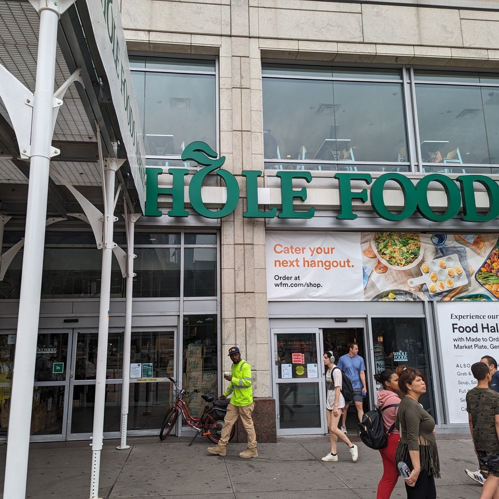 Whole foods front signage with the w cut off by a construction awning