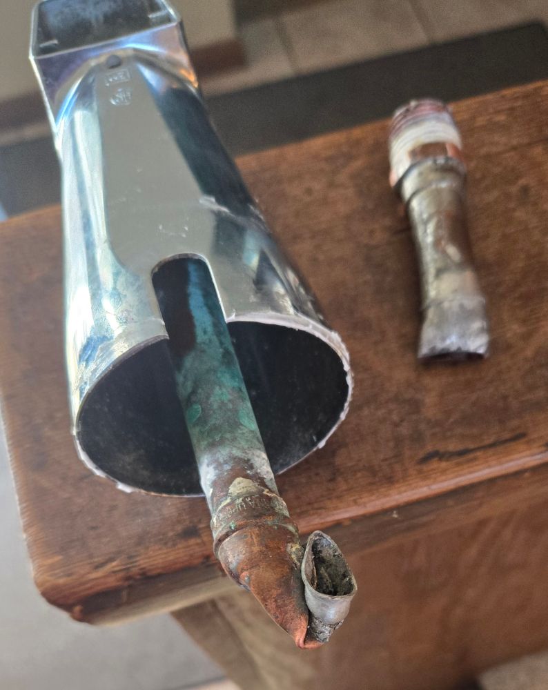 Tub spout with twisted, broken pipe attached. Too much juice.