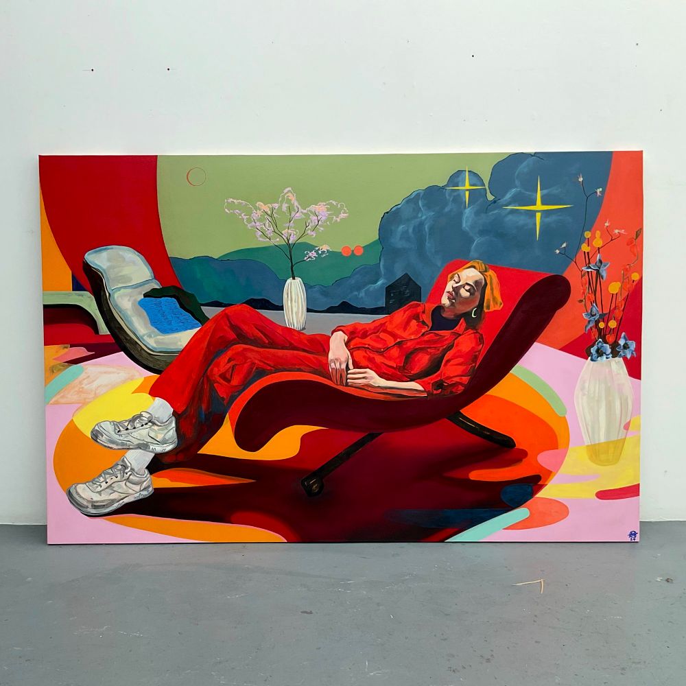 Large painting leaning against a white wall. The painting is of a sleeping woman reclining in a red 70's style chair. Behind her  is a landscape of blue clouds, with a black horizon. There are lots of abstract shapes and bright colours. There is a second empty chair in the distance and two plants in pots around her. 