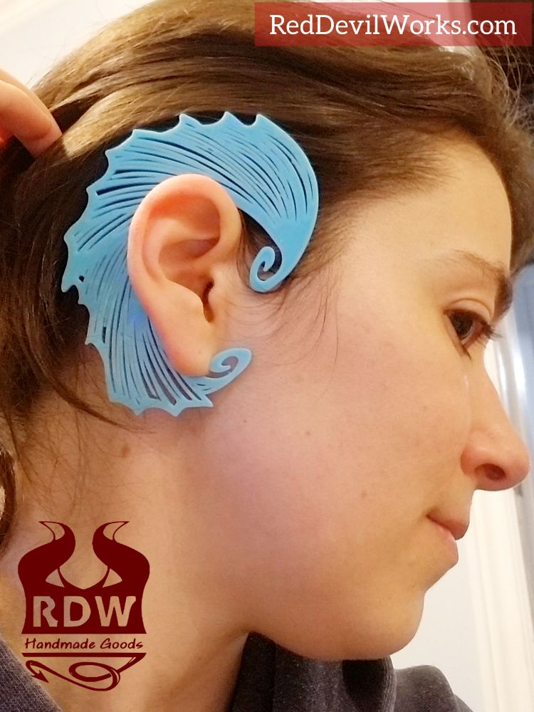 A woman wearing a light blue fins designed ear cuff by Red Devil Works 