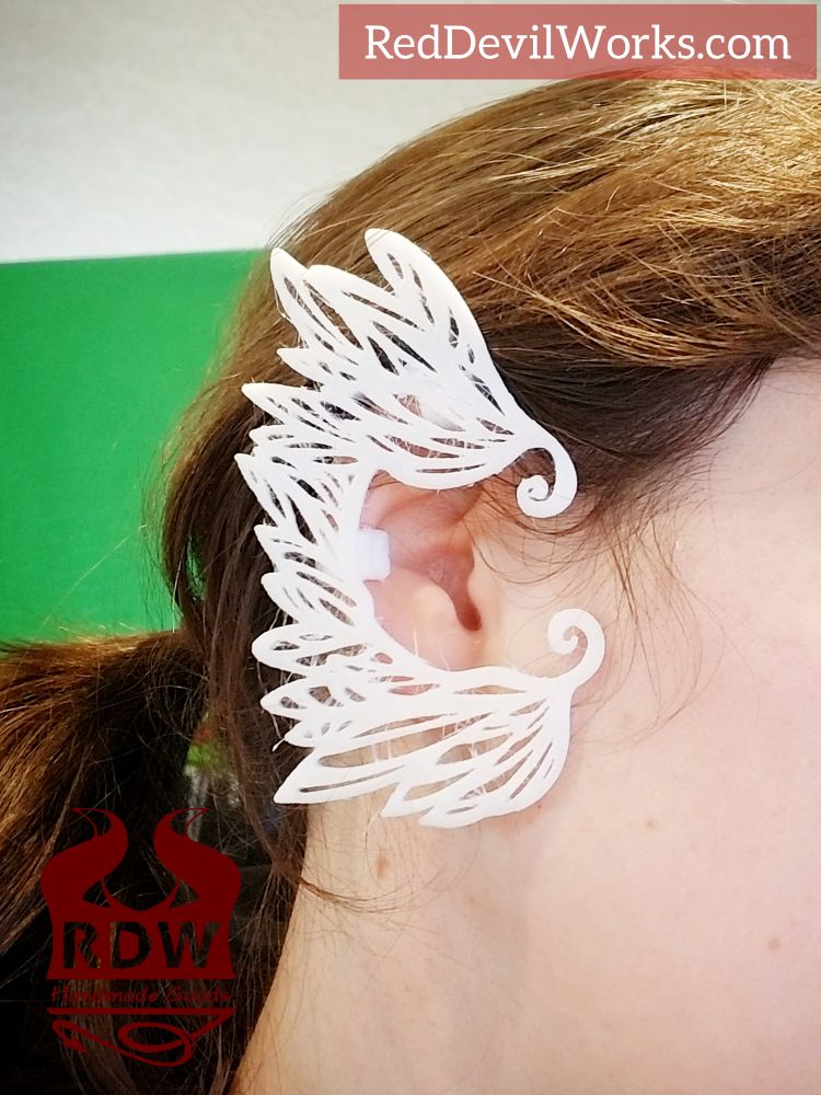 A woman wearing a white feathers designed ear cuff by Red Devil Works 